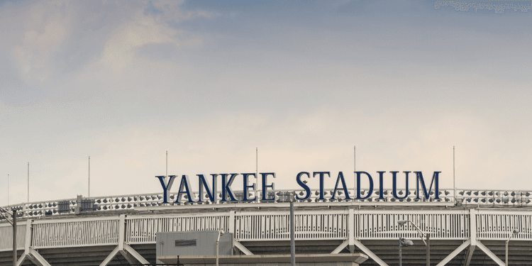 The exterior sign of Yankee Stadium against a cloudy sky