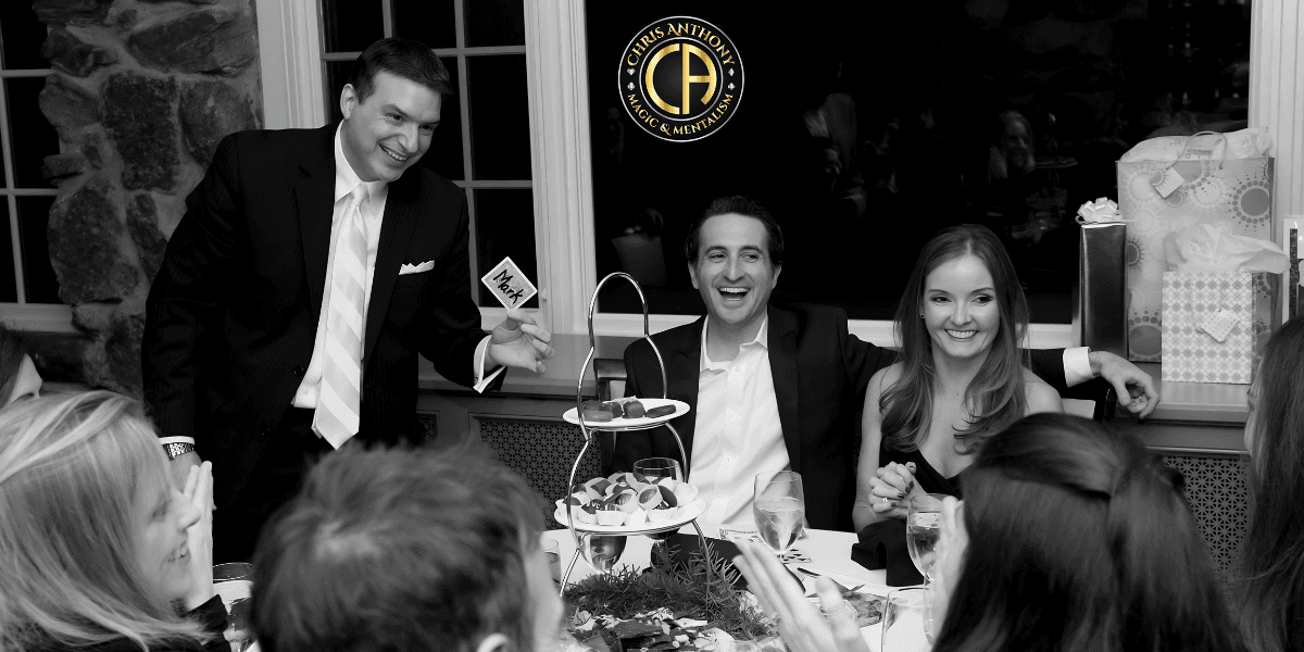 Black and white image of a festive dinner with guests enjoying desserts and drinks