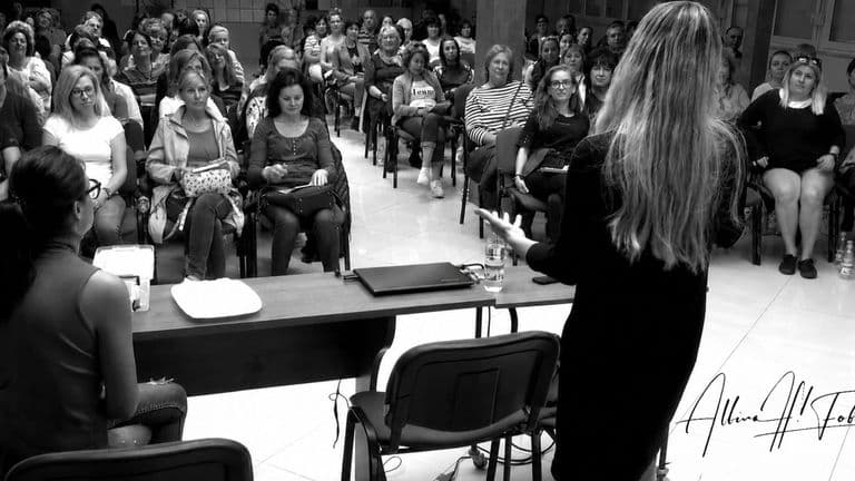 Albina Fabiani presenting to a large audience during a medical biophysics educational seminar.