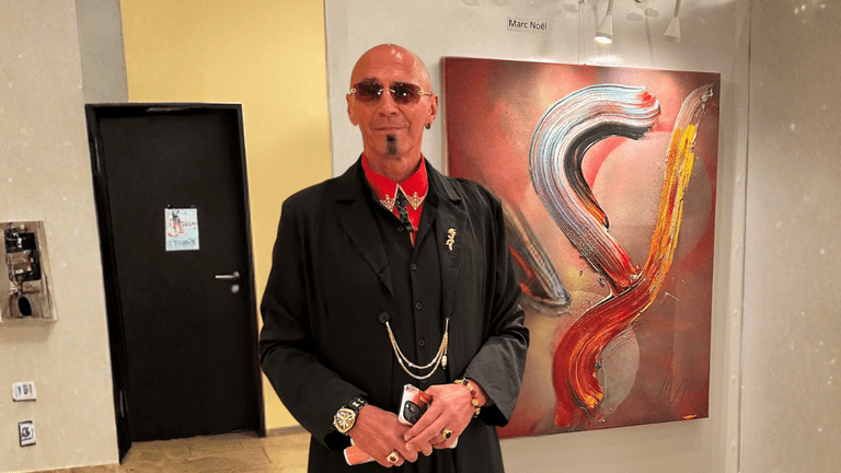 Marc Noël standing beside his vibrant quantum painting during an art exhibition at Fushigina Choowa gallery.