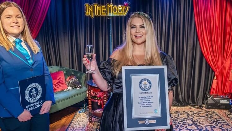 Two women holding a Guinness World Records certificate, celebrating the longest gratitude and manifestation event achievement.