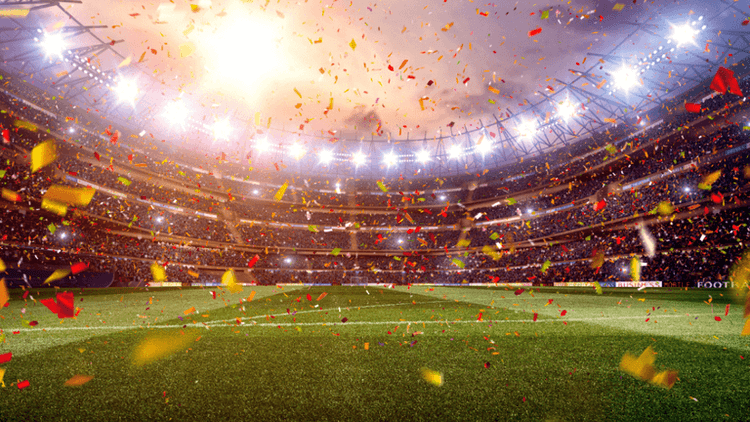 FIFA World Cup trophy beside a soccer ball on a grass field.
