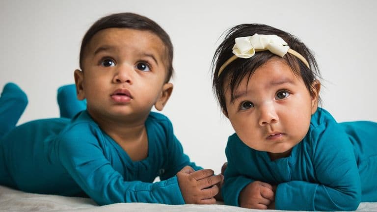 Two babies in matching teal outfits, symbolizing Tiny Culture's mission to celebrate cultural identity through baby fashion.