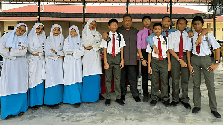 A teacher and student interact with an AI chatbot in a Malaysian classroom, showcasing AI Classroom World’s platform that enhances learning and supports educators globally.