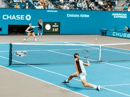 Tennis players competing on a blue court during a match at the US Open