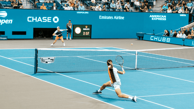 Tennis players competing on a blue court during a match at the US Open