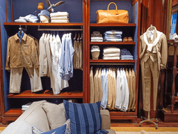 A stylish clothing display featuring neatly arranged shirts, pants, and accessories in a store