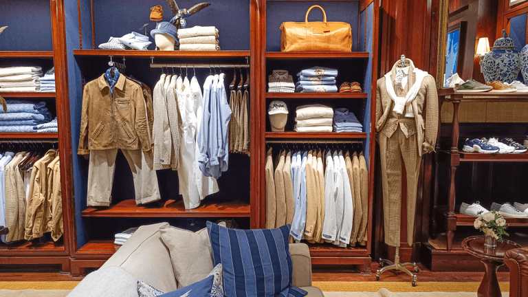 A stylish clothing display featuring neatly arranged shirts, pants, and accessories in a store