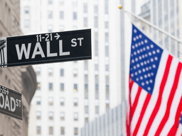 Street signs for Wall Street and Broad Street with an American flag in the background