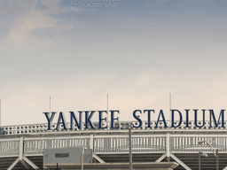 The exterior sign of Yankee Stadium against a cloudy sky