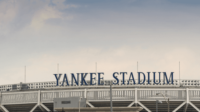 The exterior sign of Yankee Stadium against a cloudy sky