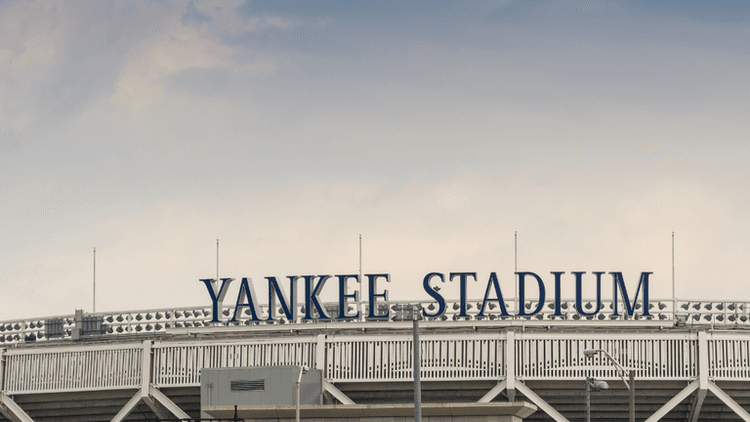 The exterior sign of Yankee Stadium against a cloudy sky