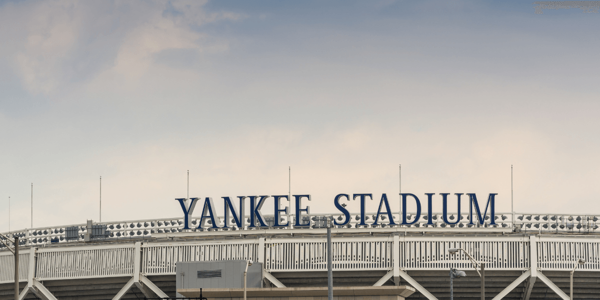 The exterior sign of Yankee Stadium against a cloudy sky
