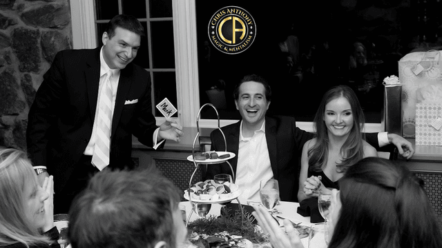 Black and white image of a festive dinner with guests enjoying desserts and drinks