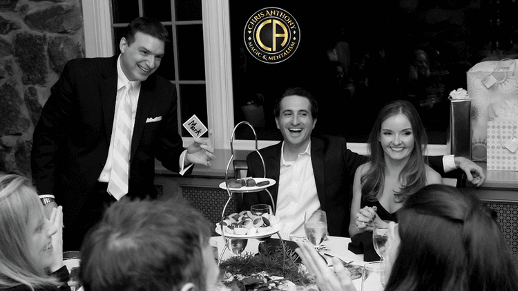 Black and white image of a festive dinner with guests enjoying desserts and drinks