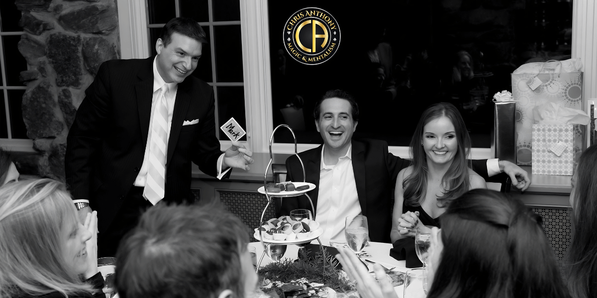 Black and white image of a festive dinner with guests enjoying desserts and drinks