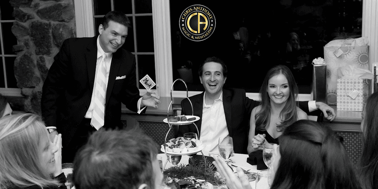 Black and white image of a festive dinner with guests enjoying desserts and drinks