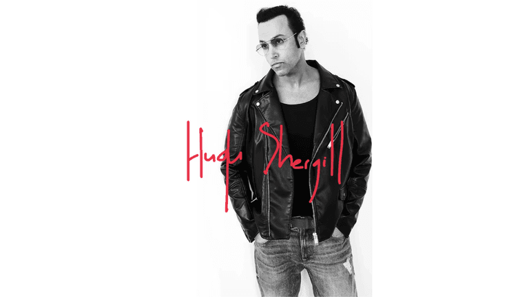 "Black and white portrait of Hugh Shergill wearing a leather jacket and sunglasses with a red handwritten signature of his name, Hugh Shergill, below the image."