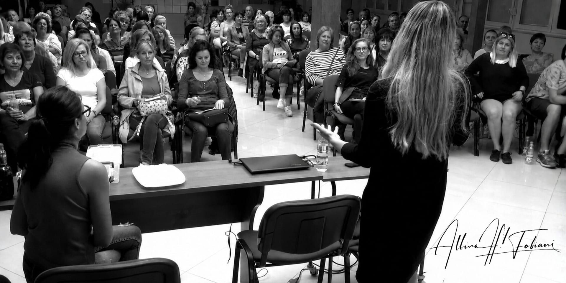 Albina Fabiani presenting to a large audience during a medical biophysics educational seminar.