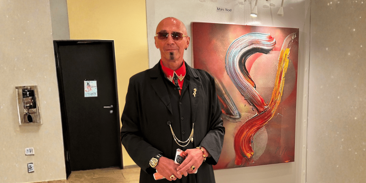 Marc Noël standing beside his vibrant quantum painting during an art exhibition at Fushigina Choowa gallery.