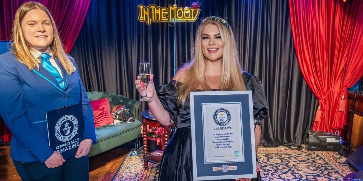Two women holding a Guinness World Records certificate, celebrating the longest gratitude and manifestation event achievement.