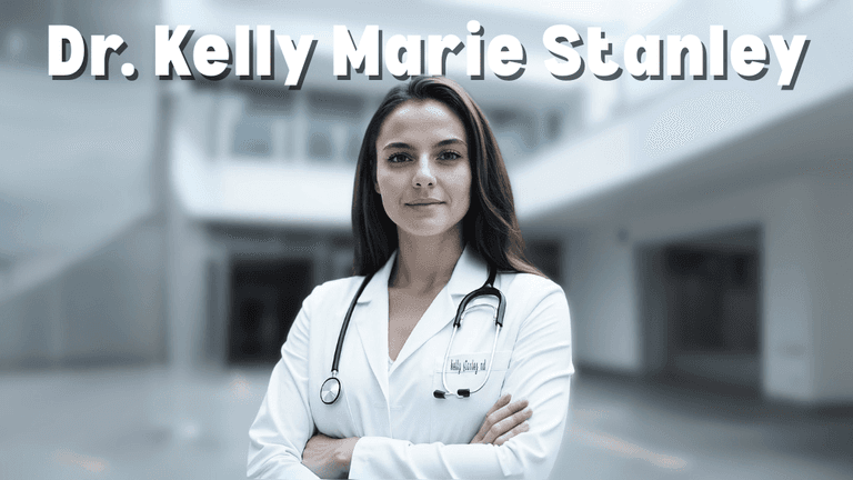 Dr. Kelly Marie Stanley, a confident and professional female doctor, stands with arms crossed in a white coat with a stethoscope around her neck in a modern medical setting.