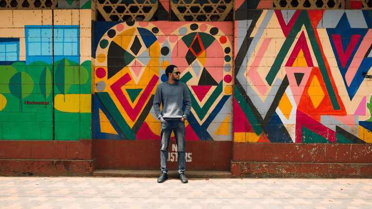 Man stands in front of colorful geometric mural, symbolizing innovation and clarity in digital financial data.