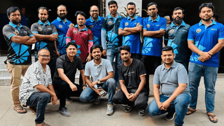 Group photo of a sports team or corporate group, featuring men in branded blue and black uniforms standing and sitting together, showcasing team spirit and camaraderie.