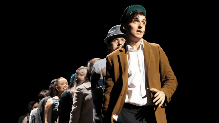 Actor leads cast in dramatic scene from Irish musical Most Peculiar Dreams on stage.