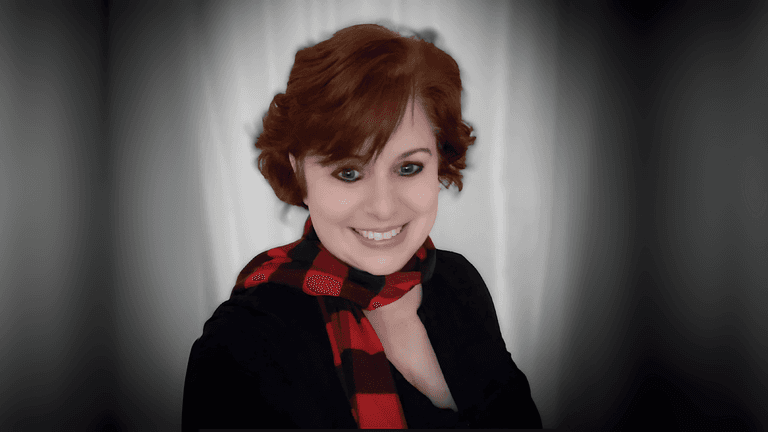Tempie W. Wade smiling with a red and black checkered scarf against a neutral background.