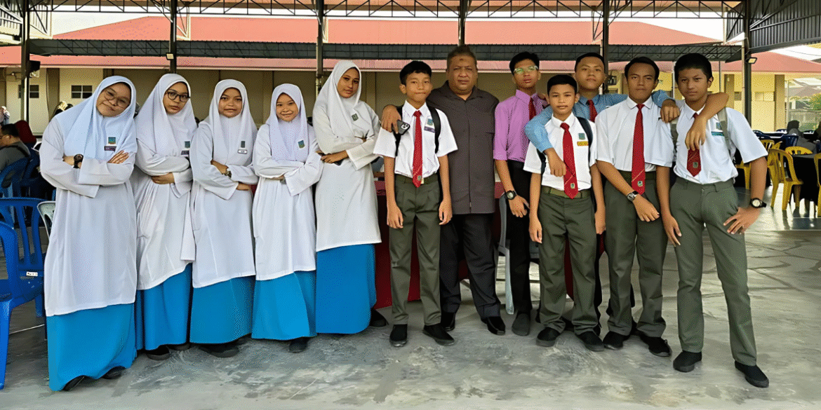 AI Classroom World A teacher and student interact with an AI chatbot in a Malaysian classroom, showcasing AI Classroom World’s platform that enhances learning and supports educators globally.