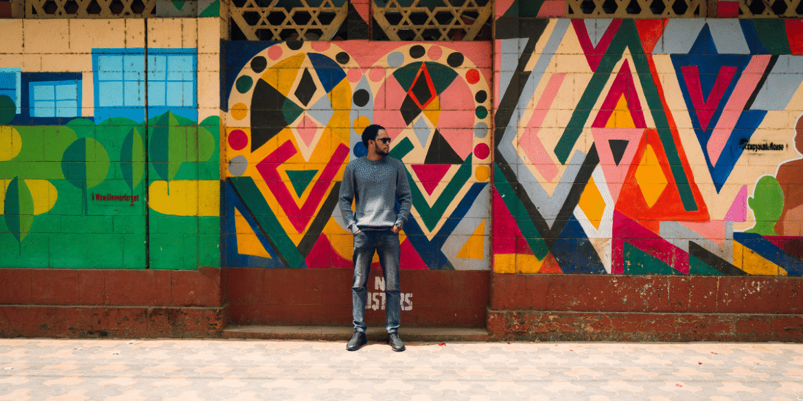 Man stands in front of colorful geometric mural, symbolizing innovation and clarity in digital financial data.