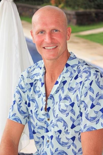 Jamie Fair smiling outdoors in a blue patterned shirt.